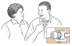 Man placing finger over tracheostomy tube to talk with woman, with detail of speaking valve..