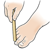 Mano con lima para uñas limando un callo en un dedo del pie.